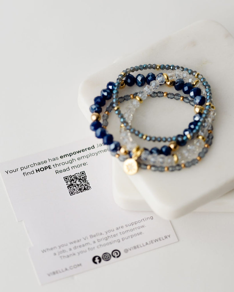 set of four beaded blue/clear bracelets with gold accents, empowering artisans with disabilities